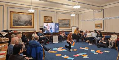 A group of people sat around a room talking about Climate Change