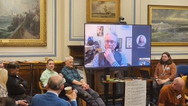 A group of people sat around a room talking about Climate Change