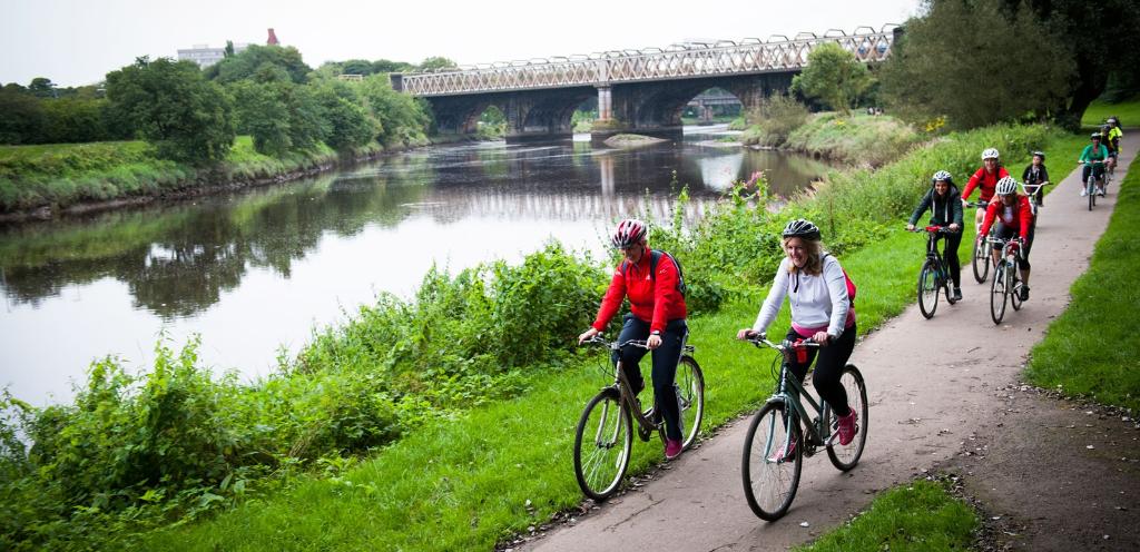 A group of cyclists on their bike alongside the Ribble in Preston