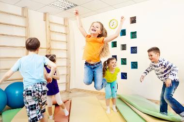 Children jumping and playing in a play room