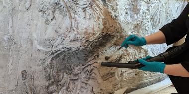 A person restoring the plaster of the artefact of Alexander Frieze at the Harris Museum.