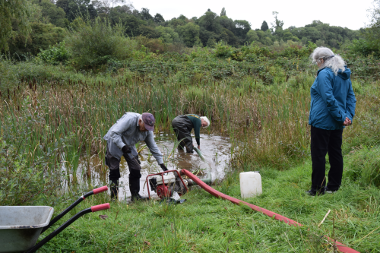 Park ranger and volunteers refilling a dried out pond